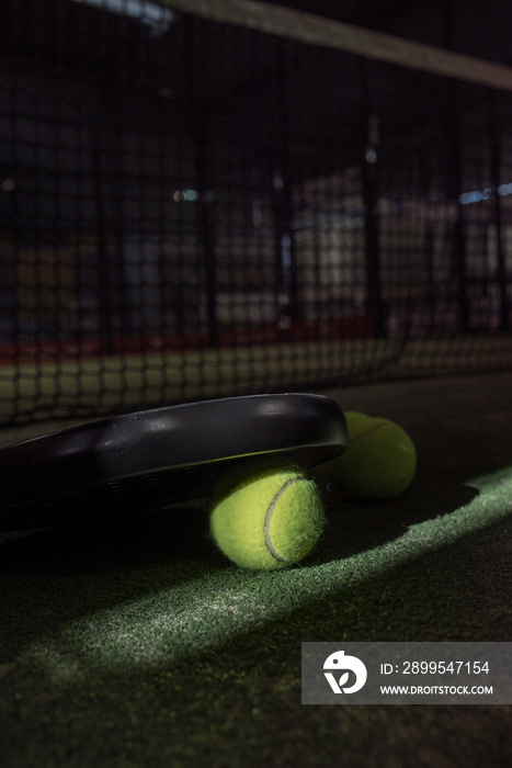 Paddle tennis net, racket and balls on turf on pitch