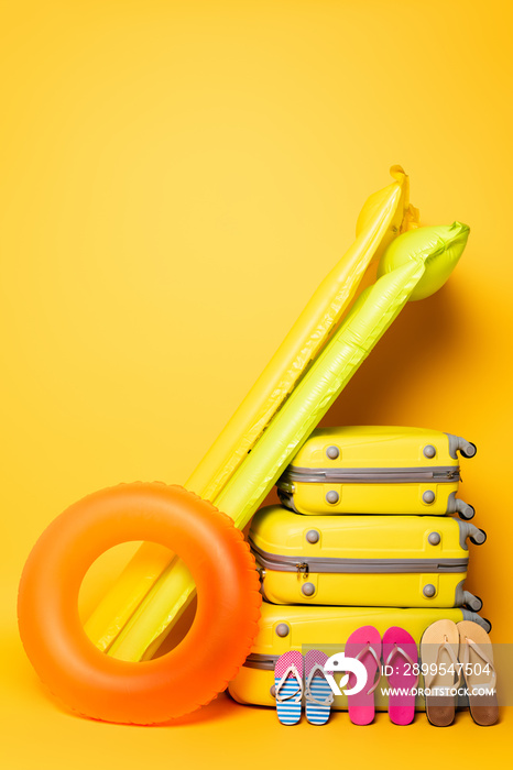 travel bags with family flip flops and pool floats on yellow