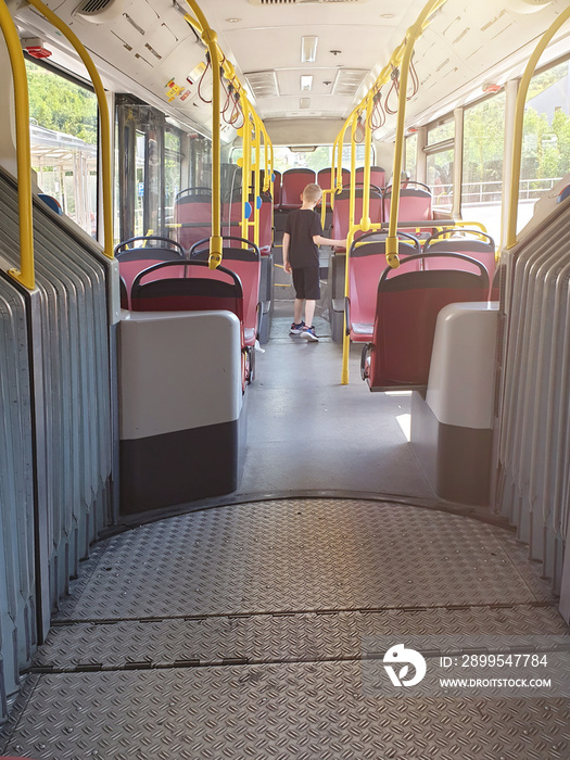 Boy in a public transport. Cute boy standing in empty schoolbus