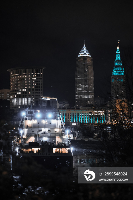 Cleveland ohio skyline at night with a ship on the cuyahoga river