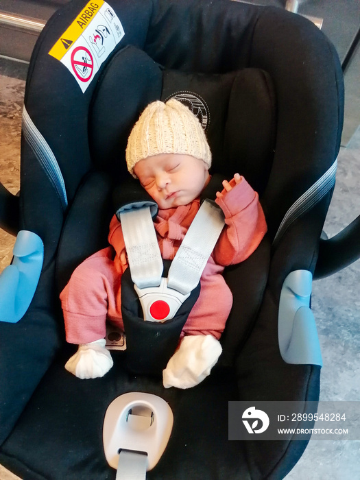 Cute newborn baby sleeping in car seat.