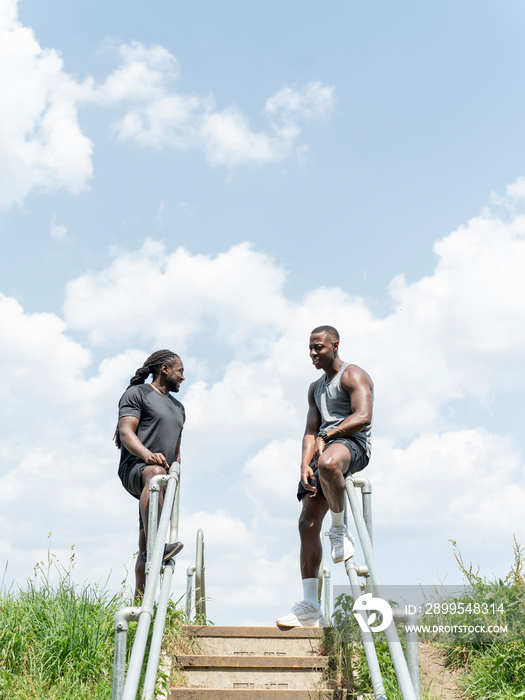 Two men exercising on stairs in park