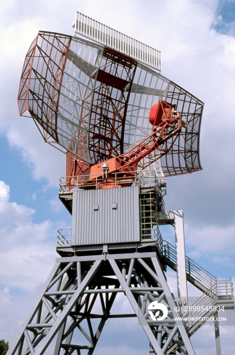An airport surveillance radar on a bright blue sky background