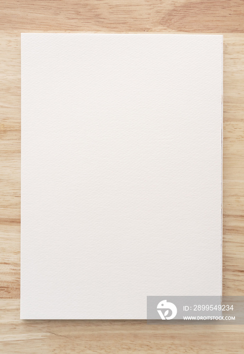 Watercolor paper texture on wood background with clipping path. White paper sheet with a torn edges.