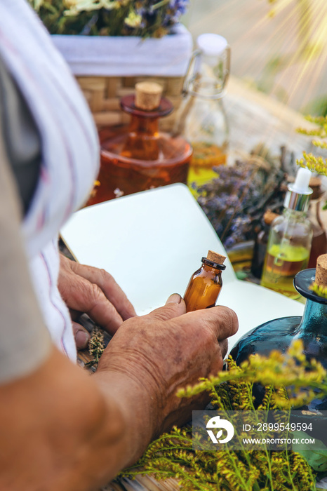 Grandmother makes tinctures from medicinal herbs. Selective focus.