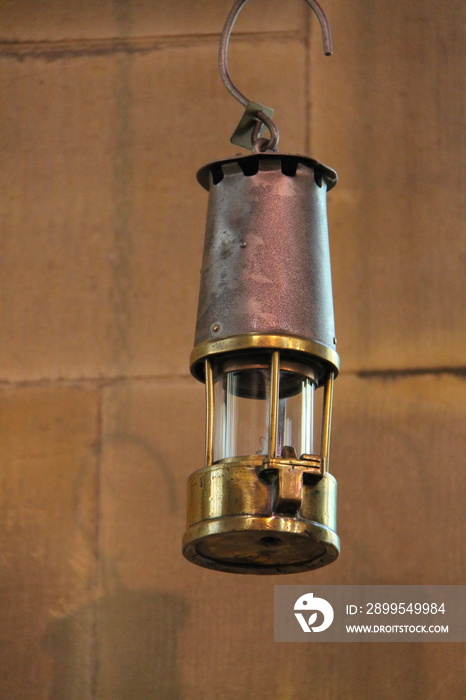 A Traditional Miners Lamp Hanging in a Room.