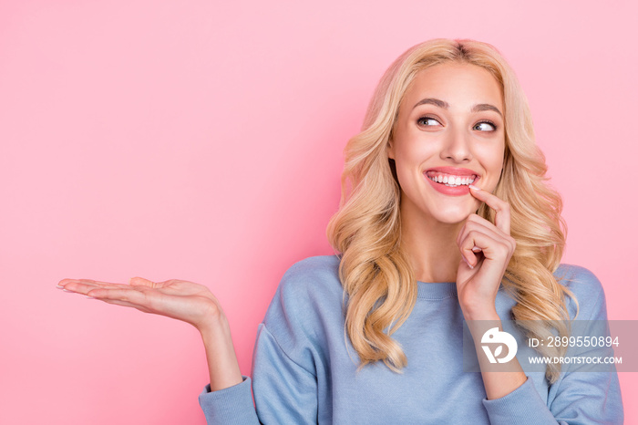 Photo of young lovely girl finger touch teeth hold hand present suggest isolated over pink color background