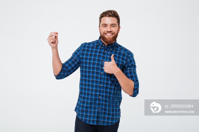 Happy bearded man holding copy space and showing thumbs up