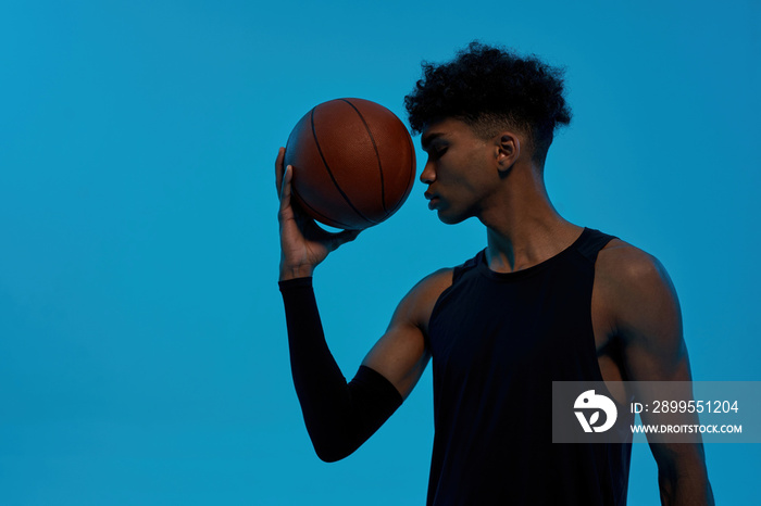 Black thoughtful sports man hold basketball ball