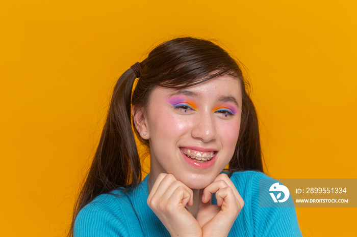 Studio portrait of smiling girl with colorful make-up