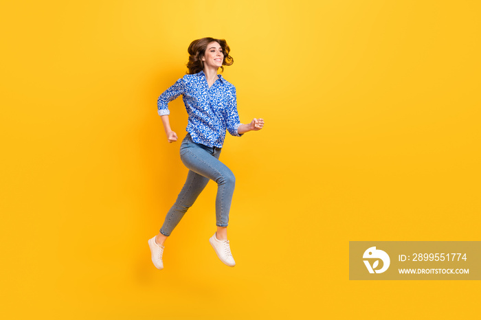 Full size profile portrait of carefree energetic girl jump running empty space isolated on yellow color background