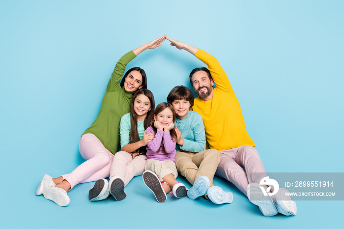 Portrait of nice attractive lovely charming cheerful big full family sitting mom dad making roof new apartment move relocation isolated on bright vivid shine vibrant blue color background