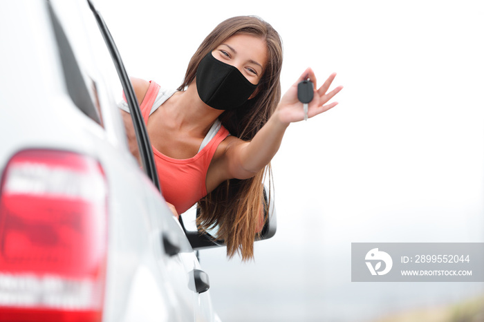 Driving new car happy driver woman wearing face mask for coronavirus showing keys. Drivers license school test success Asian girl car owner.