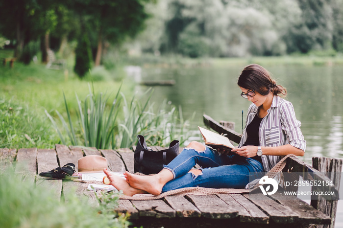 Learning / reading woman concept at summer lake