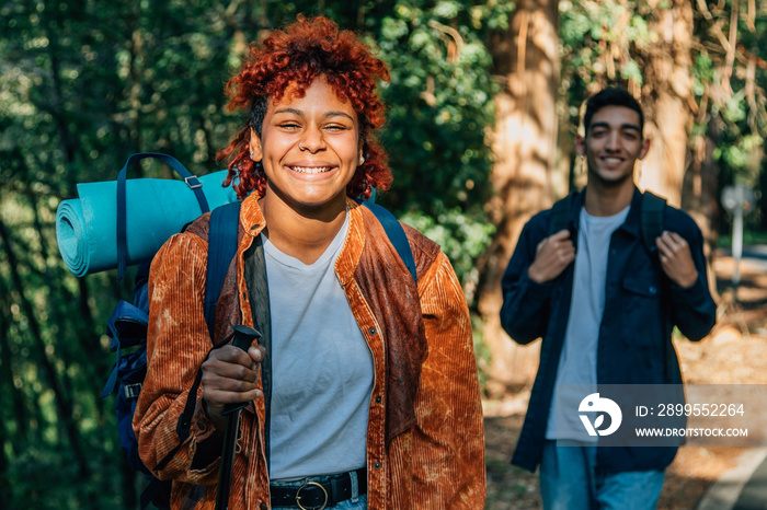 young multiethnic couple with backpacks hiking or trekking