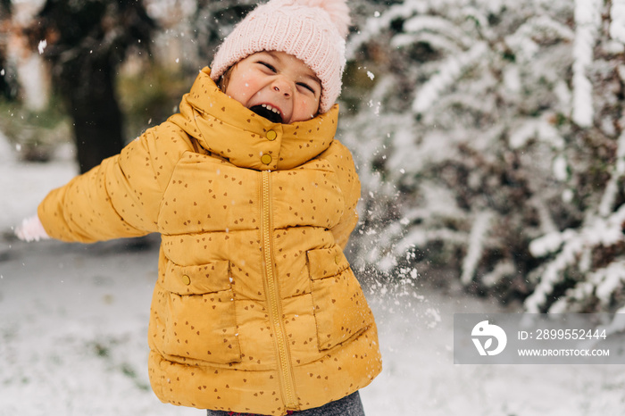 Toddler girl happy with snow day in winter. Playing outside on Christmas holiday