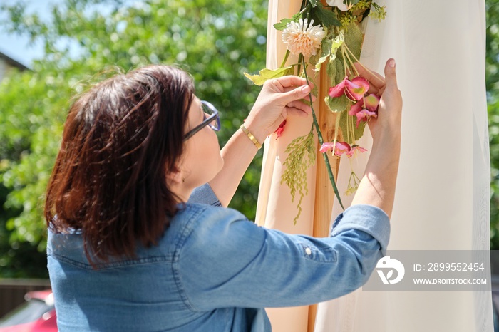 Woman making floral decor on wedding arch