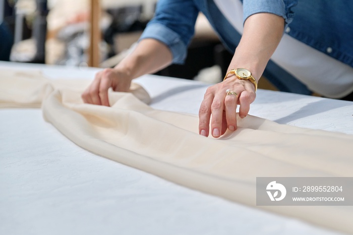 Woman making holiday decor with tablecloth on table