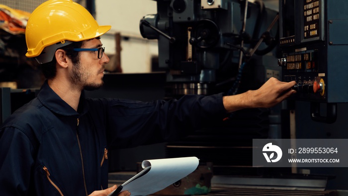 Skillful factory worker working with clipboard to do job procedure checklist . Factory production line occupation quality control concept .