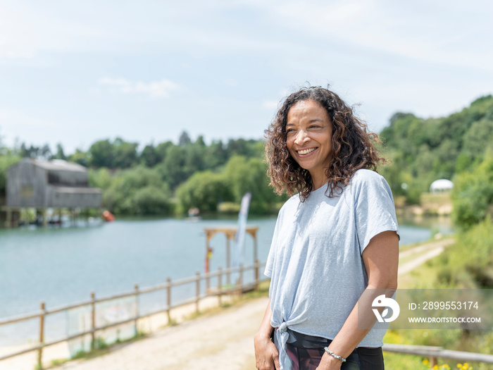 Portrait of smiling woman looking at lake