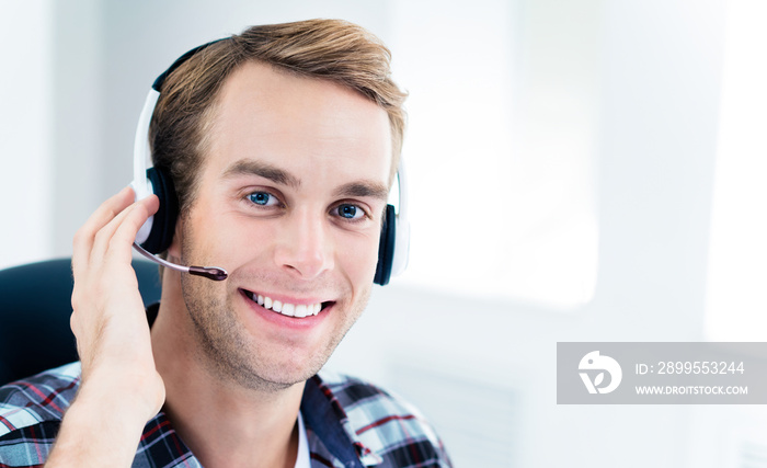 Can I help You? Portrait of friendly male customer support phone operator in headset, in smart casual wear. Consulting and assistance, service call center concept.