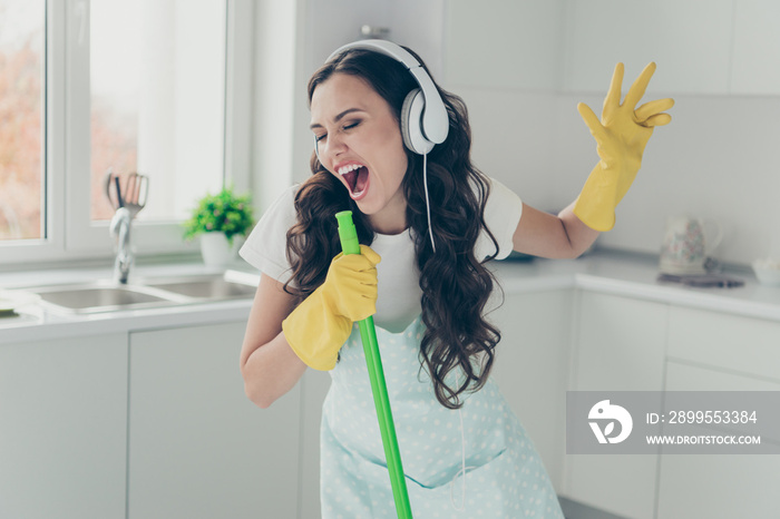 Full length body size portrait of her she nice beautiful lovely cheerful cheery funny wavy-haired house-wife using broom like mic fooling having fun in modern light white interior indoors