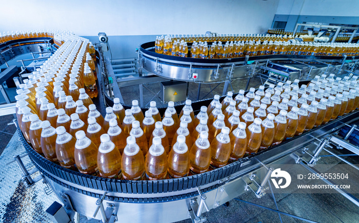 Conveyor belt with bottles for juice or water at a modern beverage plant