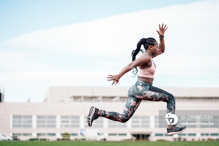 African-American young athlete sprinter jumping