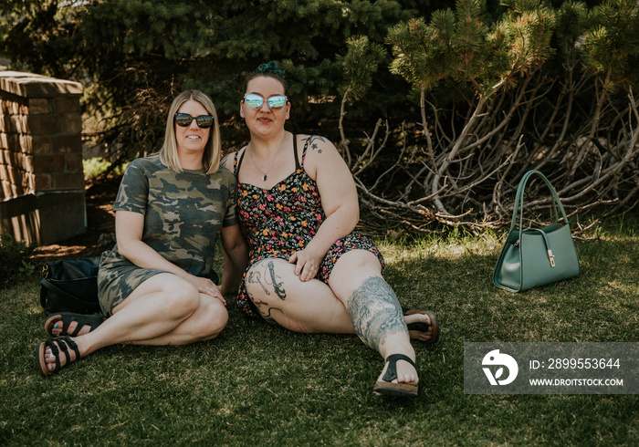 2 women sitting on grass