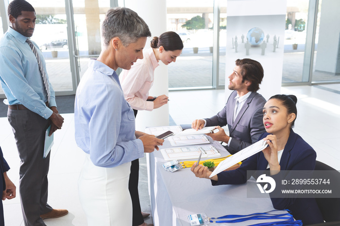 Business people checking in at conference registration table