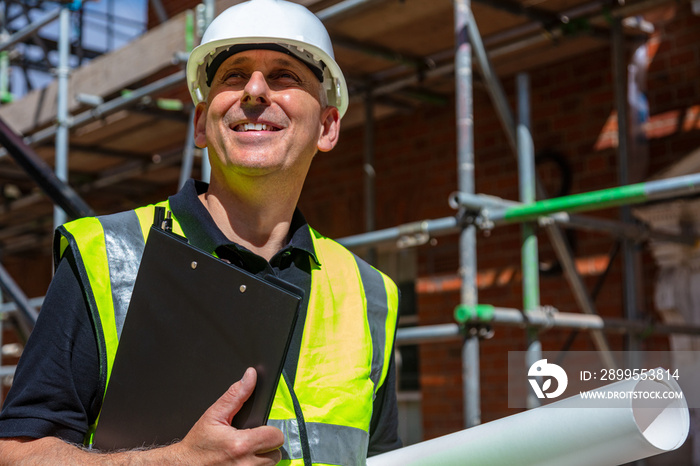 Male Builder Architect Contractor on Building Site Clipboard and Plans