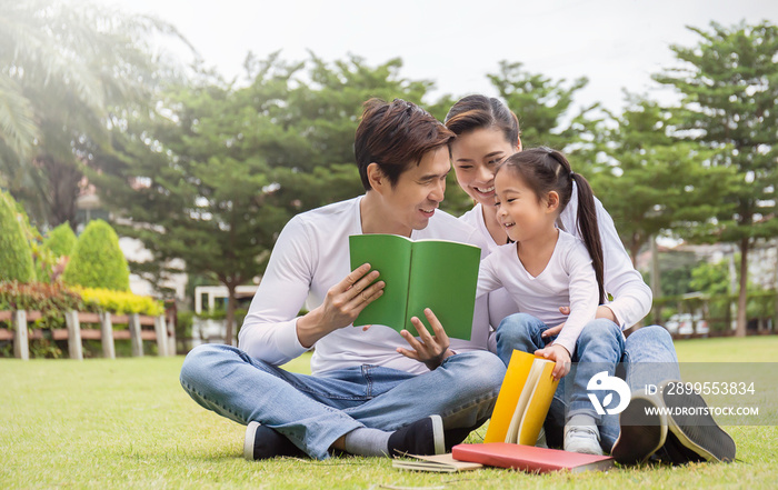 Portrait of happy asian family man woman and little girl reading outside. Asian family having fun read book together outdoor.  Home school education family lifestyle spring summer, quarantine concept