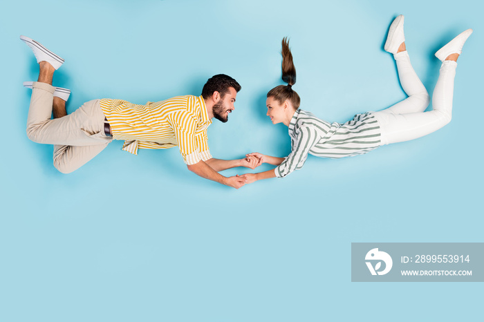 Top view above high angle flat lay flatlay lie concept full length body size view of nice cheerful couple flying holding hands isolated on bright vivid shine vibrant blue turquoise color background