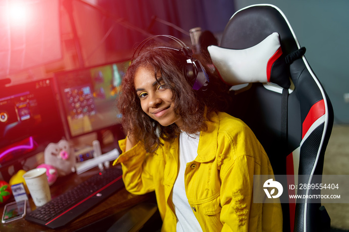 Shot of the beautiful pro gamer girl playing online video game on personal computer. Neon room. eSport cyber games internet.