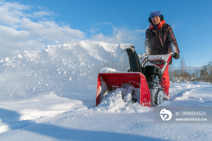 Snow blower in action in nice winter day.