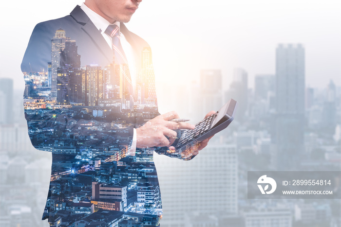 the double exposure image of businessman or accountant using a calulator overay with cityscape image and white copy space. the concept of accounting, business, financial, economy and invesment.