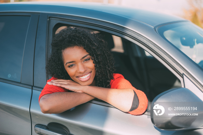 Young black woman sitting in the car smiling