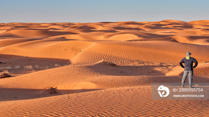 lonely male figure in a sand dunes field, dusty and windy morning in San Rafael Swell area in Utah (Lower San Rafael Road), panoramic web banner