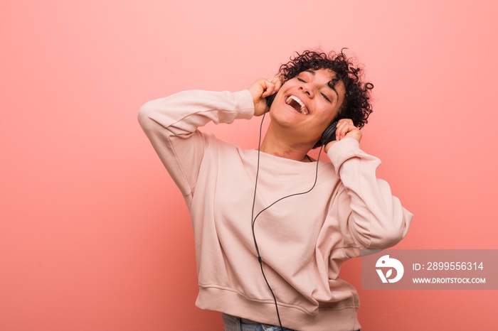 Young african american woman with a birthmark dancing and listening to music with a headphone