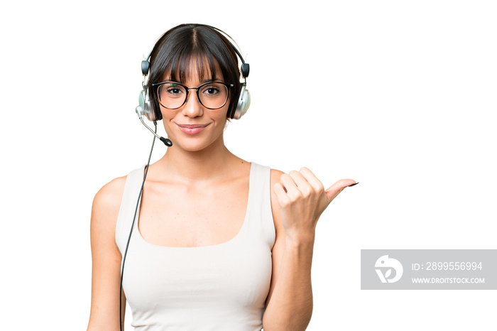 Telemarketer caucasian woman working with a headset over isolated background pointing to the side to present a product