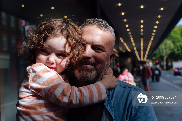 Dad and daughter enjoying in shopping together. He is carrying her.