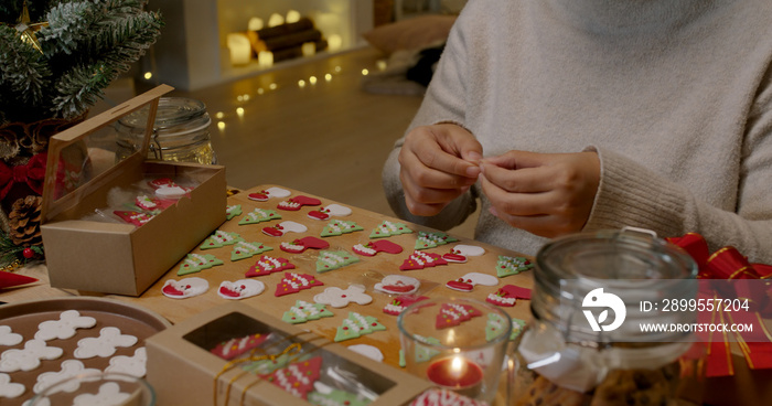 Asia woman happy enjoy fun make craft gift for X’mas night party sweet snack cooking recipe on table in good warm relax time. Cute smile gingerman bakery icing sugar glaze with red green white color.