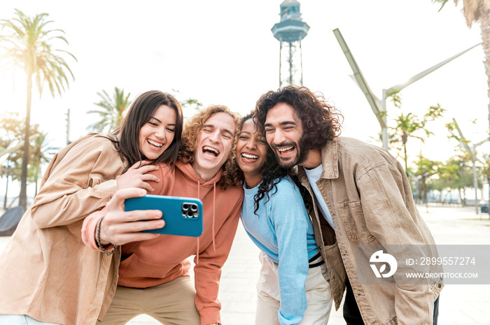 Group multiracial friends taking selfie picture with smartphone outdoor - Happy young men and women laughing at camera - Youth concept with students having fun at holiday time