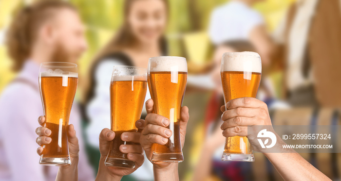 Friends clinking glasses with beer during celebration of Octoberfest outdoors