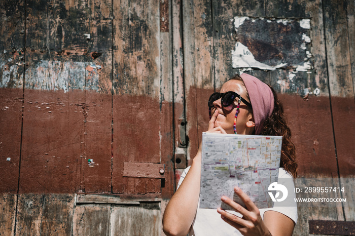 .Young woman doing sightseeing around the beautiful city of Bordeaux in France. Using a map because she got lost. Travel photography. Lifestyle.