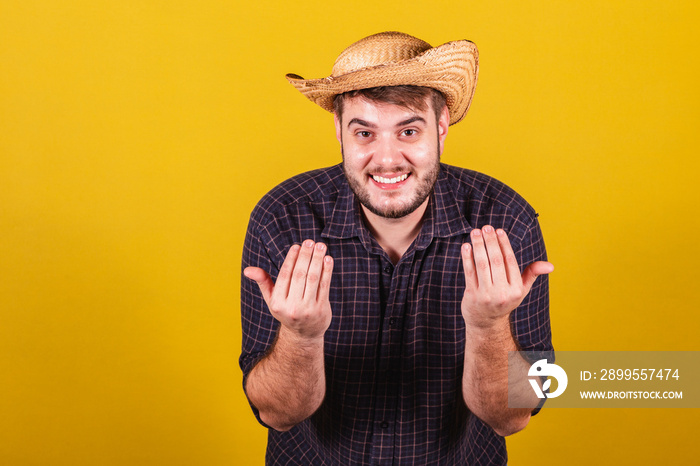 Man wearing typical clothes for Festa Junina. Feast of Arraiá de São João. come, come, only here. calling with your hands.