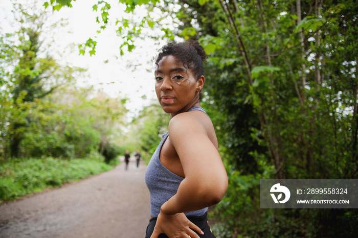 Young curvy woman with vitiligos standing in the park in workout clothes