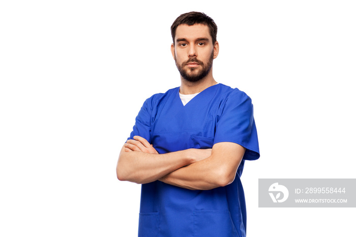 healthcare, profession and medicine concept - doctor or male nurse in blue uniform with crossed arms over white background