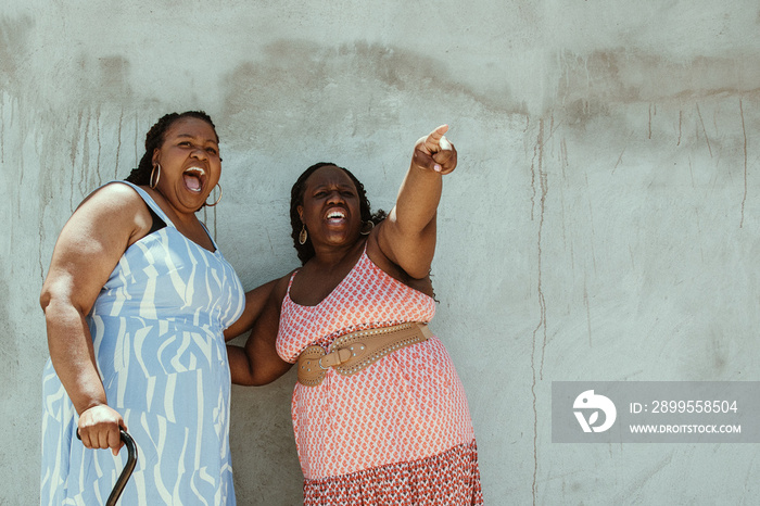 2 African American women stand and point