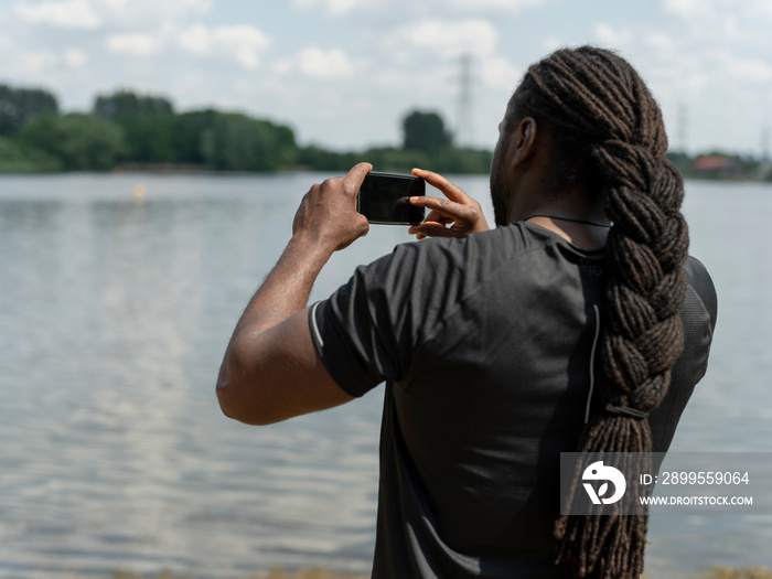 Man photographing lake with smart phone